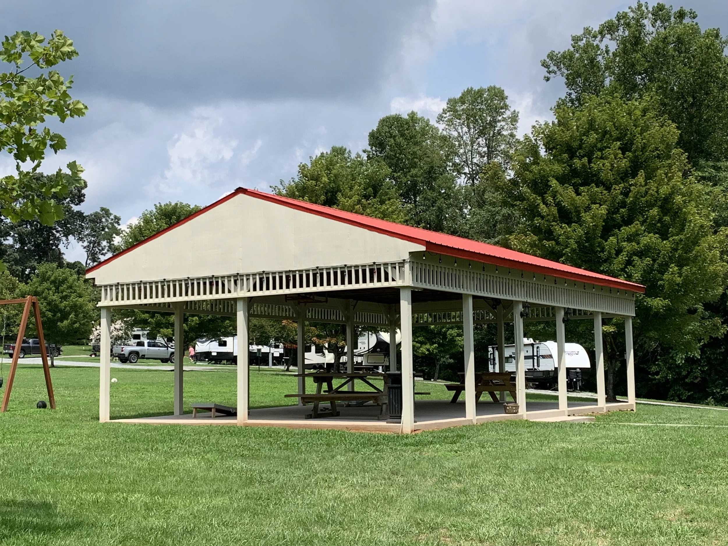 a pavillion in a grassy field  surrounded by trees